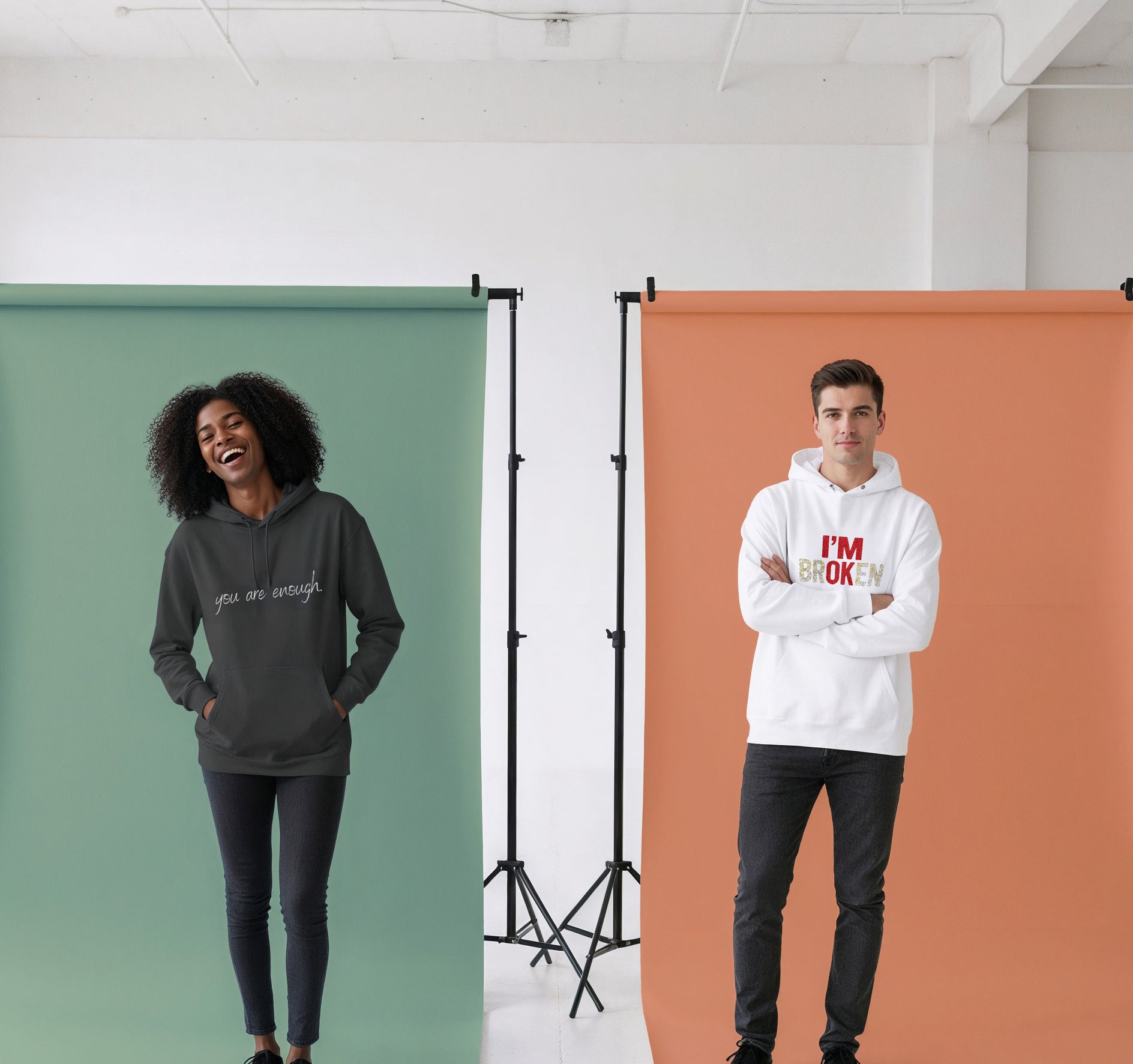 Two people standing in front of green and orange backdrops with text on their clothing.